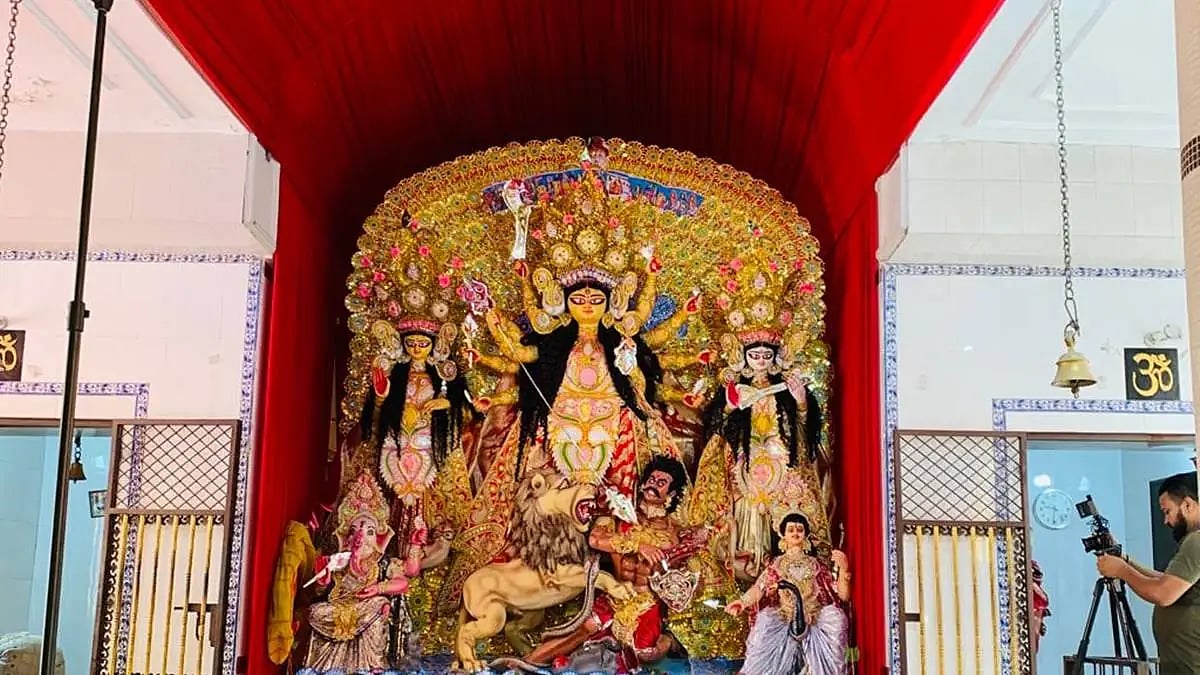 Durga Puja pandal with idols of Goddess Durga and other deities in a vibrant, decorated setting.