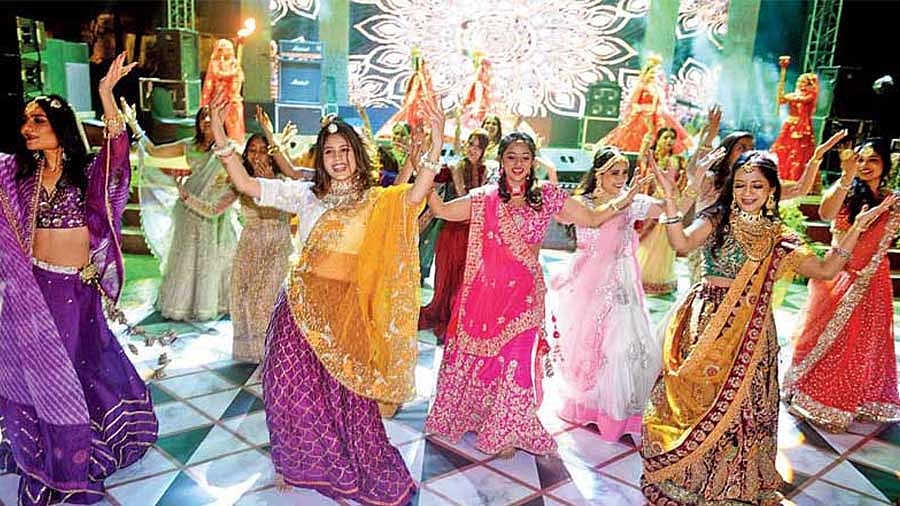 A group of women performing dandiya in traditional attire