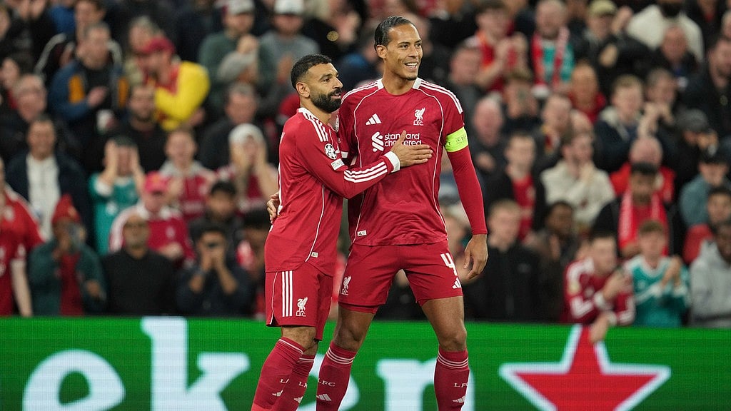 AP/Jon Super : Liverpool's Mohamed Salah, left, celebrates with his teammate Virgil van Dijk after scoring his side's second goal during the Champions League opening phase soccer match between Liverpool and Atletico Madrid at Anfield.