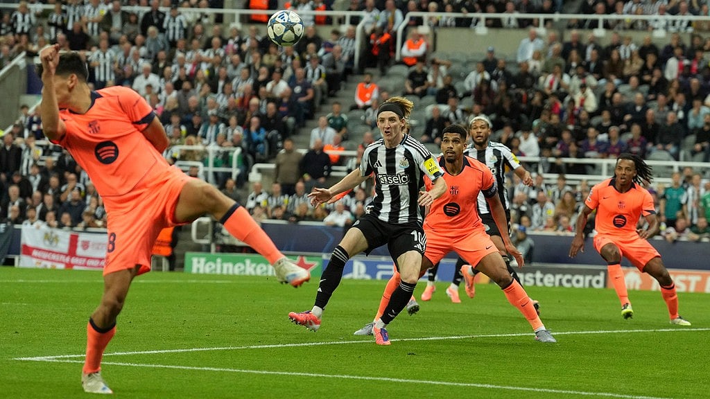 AP/Jon Super : Newcastle's Anthony Gordon, second left, and Barcelona's Ronald Araujo look on the ball during the Champions League, opening phase soccer match between Newcastle and Barcelona in Newcastle.