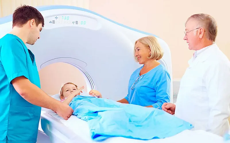A child getting a CT Scan with medical professional around him