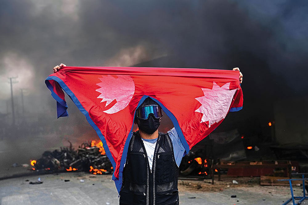 | Photograph: AP : Violent Day: A protester shouts slogans after burning down a police station in Kathmandu