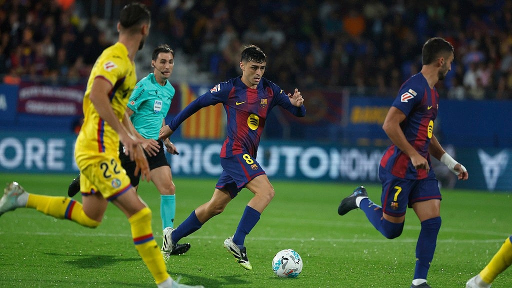 AP/Joan Monfort : Barcelona's Pedri fights for the ball against Getafe's Domingos Duarte during a Spanish La Liga soccer match between FC Barcelona and Getafe at the Johan Cruyff stadium in Barcelona.