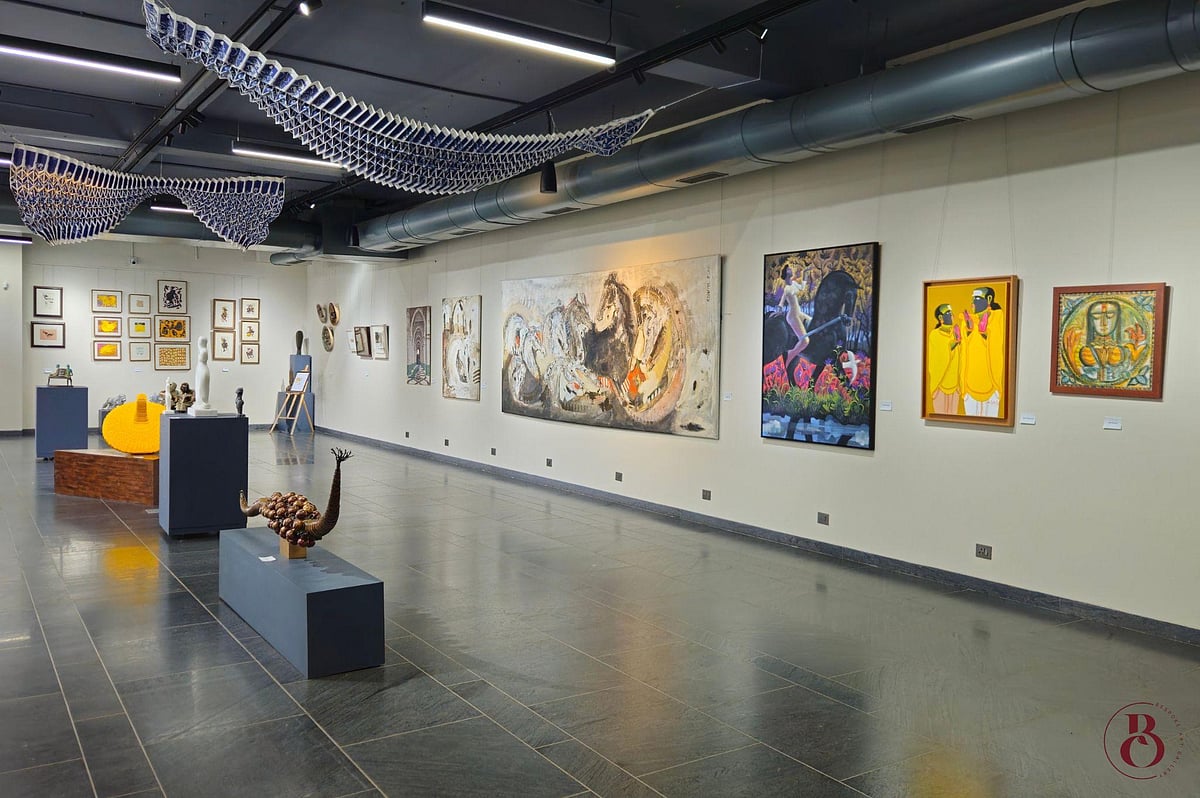 A long hallway in an art gallery featuring various framed artworks on the walls.