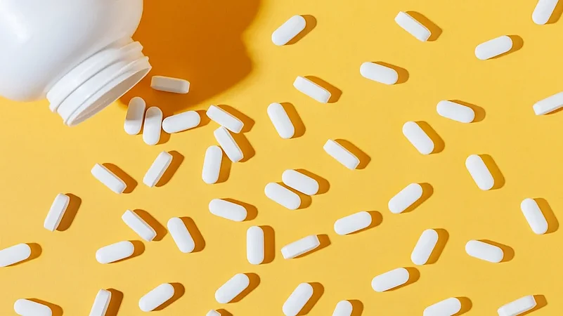 A bottle of tablets spilled over on yellow background