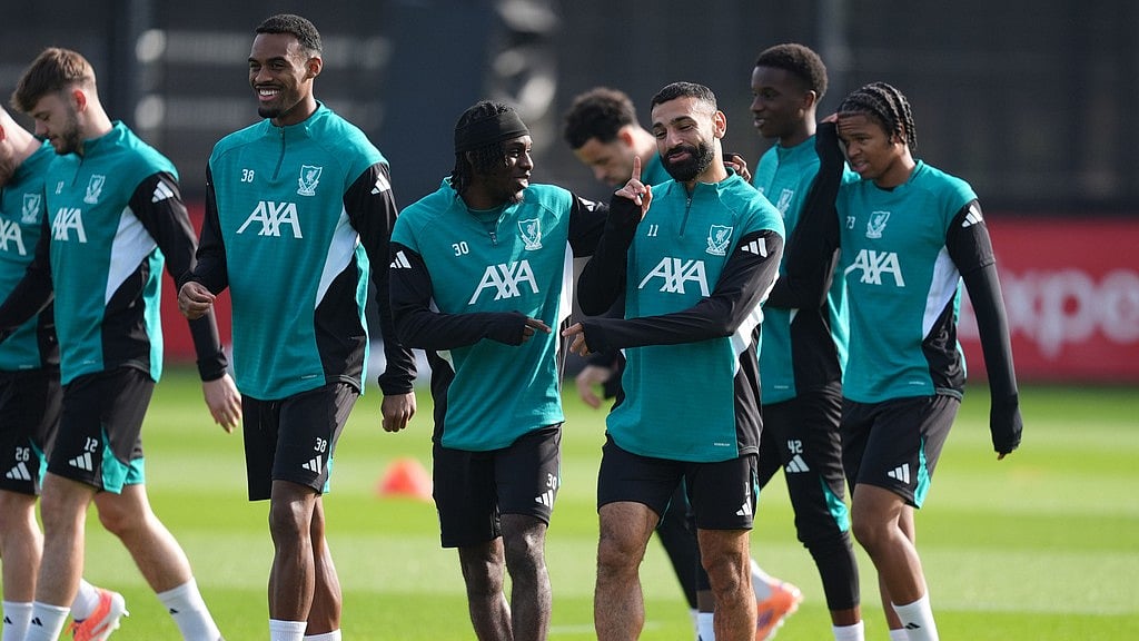 Martin Rickett/PA via AP : Liverpool's Jeremie Frimpong, Mohamed Salah (right) and Ryan Gravenberch (left) during a training session in England.