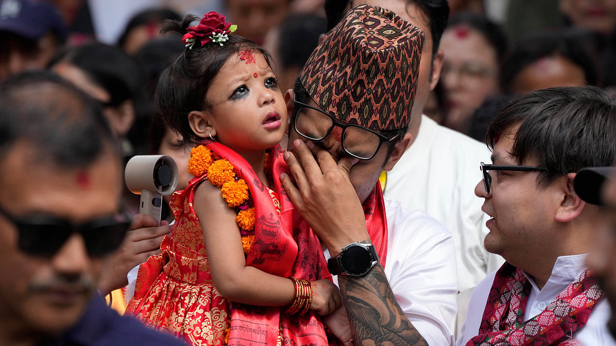 (AP Photo/Niranjan Shrestha) : Nepal's newly appointed living goddess, Kumari Aryatara Shakya, is carried by her father as they walk towards Kumari Ghar, the temple palace where she will be residing in Kathmandu, Nepal, Tuesday, Sept. 30, 2025. 