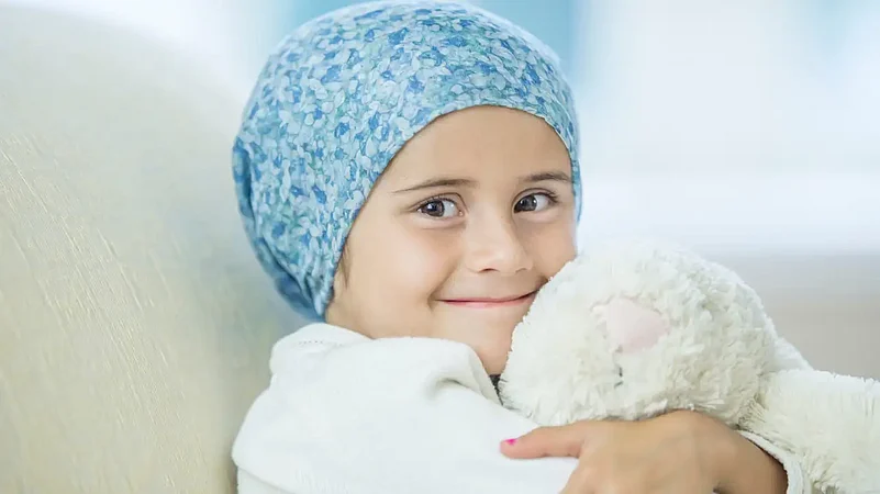 Smiling child wearing a blue patterned headscarf, hugging a stuffed animal with warmth and comfort