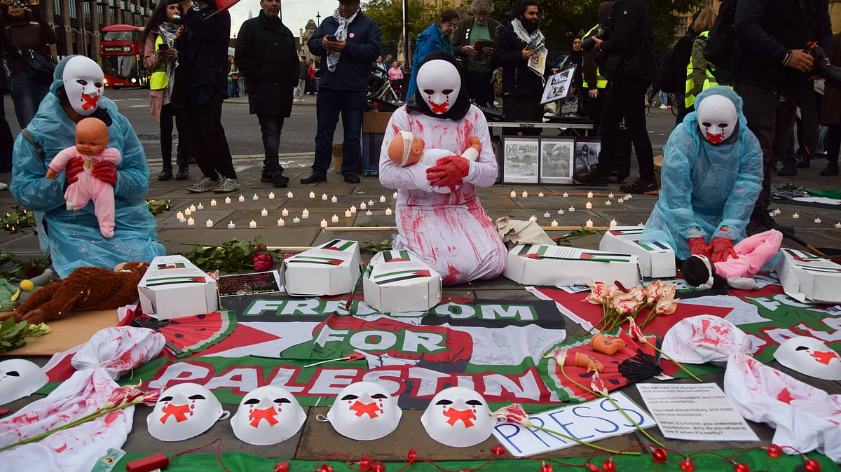Protesters wearing masks hold dolls representing hurt and dying children as Palestine supporters stage a vigil in Parliament Square for over 41,000 people killed in Gaza on the first anniversary of the Israel-Hamas war, which began when Hamas killed and abducted Israelis at the Nova music festival on 7th October 2023. - imago |