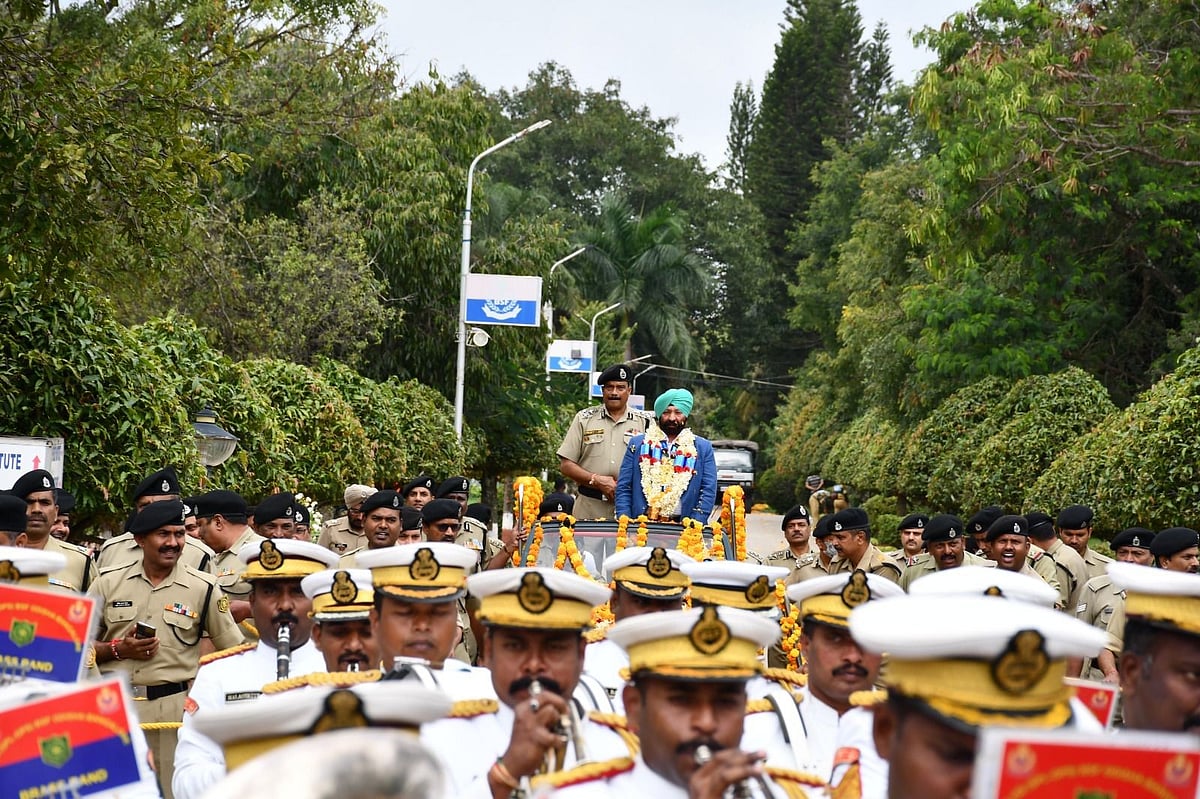 Military personnel in uniform salute during a ceremonial procession.