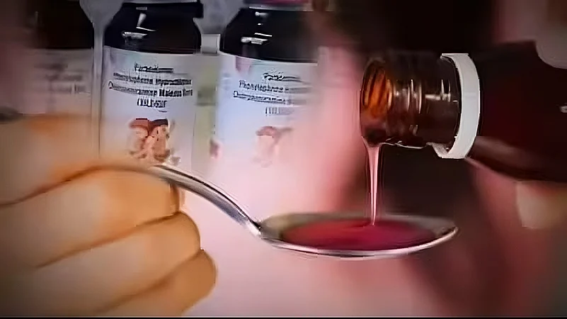a person pouring cough syrup onto a spoon