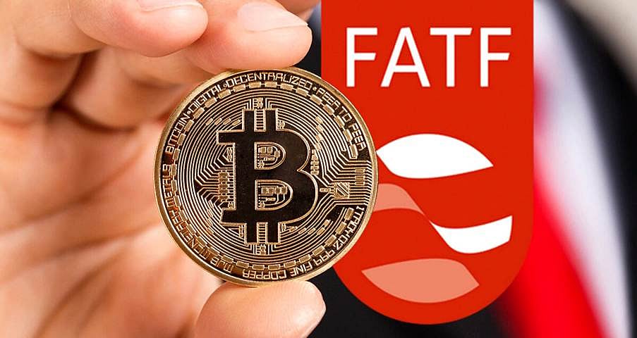 A Bitcoin coin held in front of a background with the letters FATF.