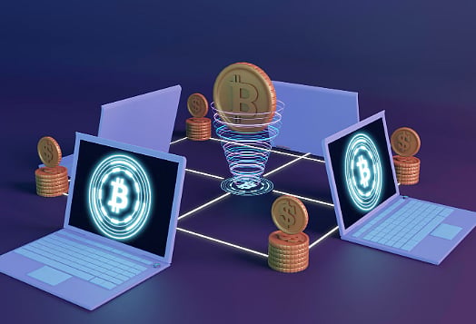 Bitcoin digital transaction between laptops with coins and blockchain network visuals.