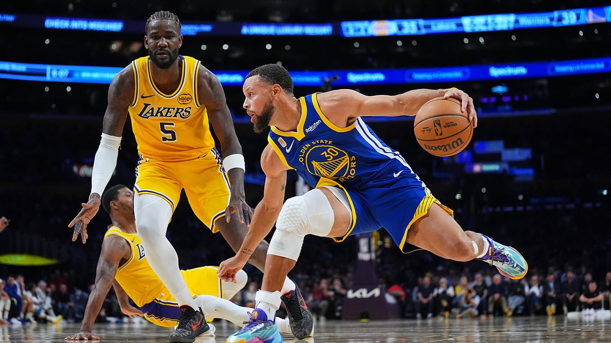 APEthan Swope : Golden State Warriors guard Stephen Curry (30) dribbles in front of Los Angeles Lakers center Deandre Ayton (5) during the first half of an NBA basketball game.