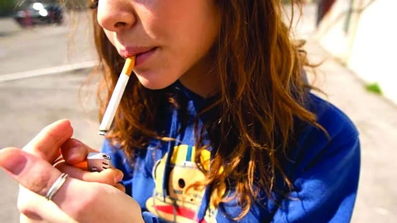 a young girl lighting a cigarette