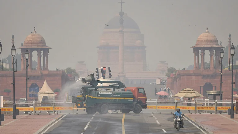 New Delhi: An anti-smog gun sprays water droplets to curb air pollution, with Rashtrapati Bhavan in the backdrop, as air quality deteriorates across northern India, in New Delhi, Tuesday, Oct. 21, 2025. - - PTI