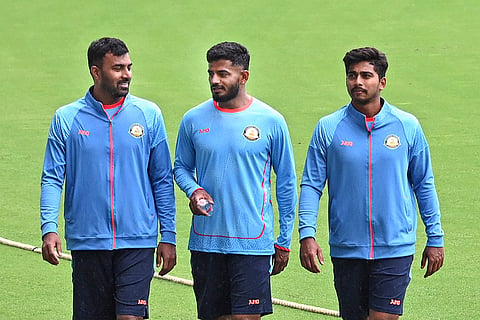 Vidarbha's Akshay Karnewar, left, Shubham Kapse, center, and Darshan Nalkande walk on the field as rain and bad light delay the start of the Ranji Trophy match against Jharkhand at VCA Stadium, in Nagpur, Maharashtra.