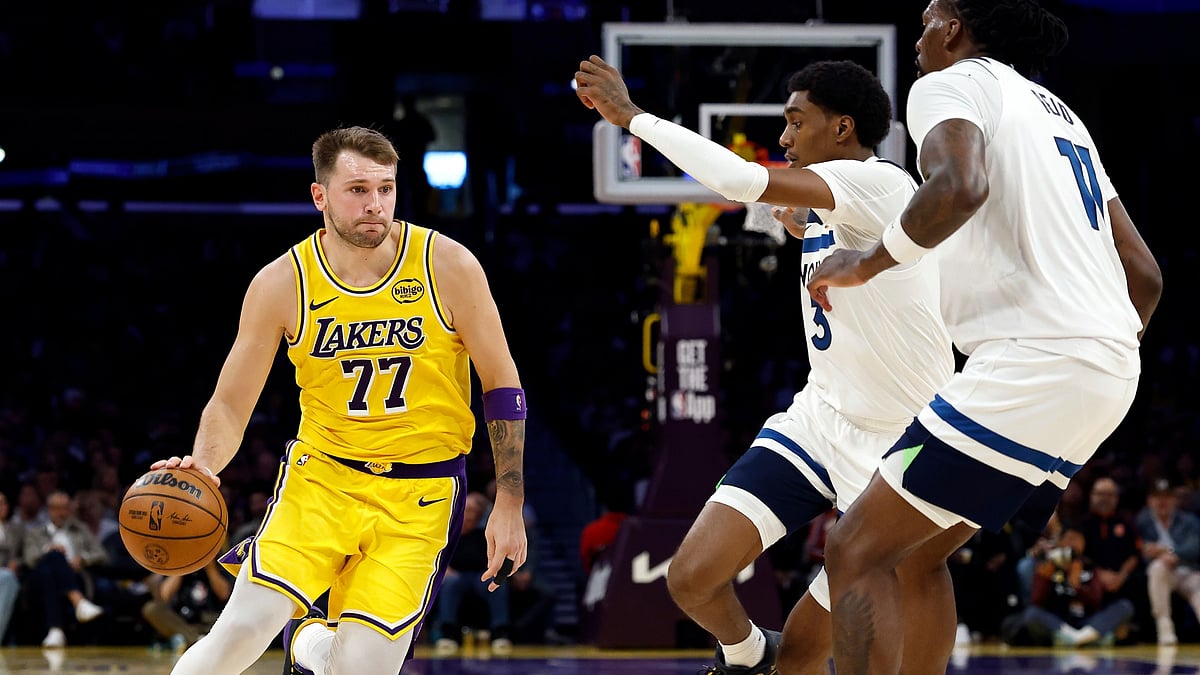 Luka Doncic #77 of the Los Angeles Lakers controls the ball against Jaden McDaniels #3 of the Minnesota Timberwolves in the first half at Crypto.com Arena on October 24, 2025 in Los Angeles, California.