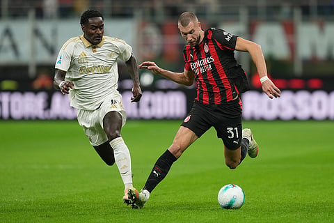 Pisa's Ebenezer Akinsanmiro guards AC Milan's Strahinja Pavlovic during the Serie A soccer match between AC Milan and Pisa in Milan, Italy.