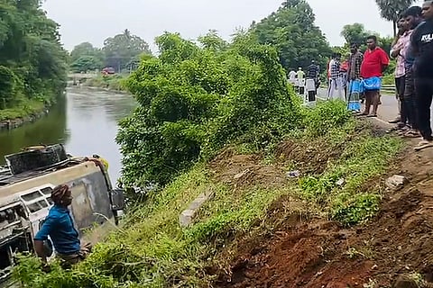 People look at the wrecked remains of a bus that toppled with 31 passengers into a canal after the driver allegedly lost control near Silaayathi in Tiruchirapalli.
