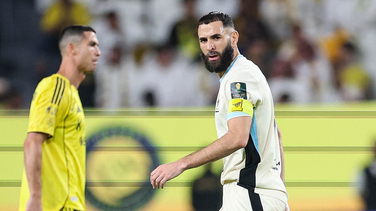 X/ittihad_en : Cristiano Ronaldo (left) watches on as Karim Benzema walks by.