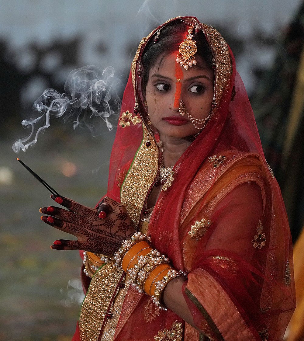 | Photo: PTI/Atul Yadav : A woman offers prayers on the last day of the ‘Chhath Puja’ festival celebrations, in Ghaziabad.
