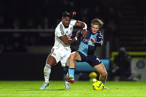Fulham's Adama Traore, left, and Wycombe Wanderers' Sam Bell battle for the ball during the English League Cup fourth round soccer match between Wycombe Wanderers and Fulham, in High Wycombe, England.
