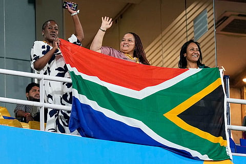 South Africa's supporters celebrate with their national flag during the ICC Women's Cricket World Cup first semifinal match between England and South Africa at Barsapara Cricket Stadium in Guwahati.