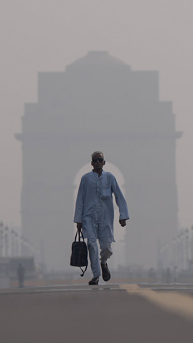 | Photo: IMAGO/Amarjeet Kumar Singh : Commuters make their way past India Gate amid smoggy conditions in New Delhi.