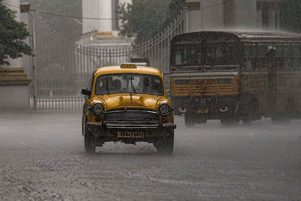 | Photo: PTI/Manvender Vashist Lav : Rainfall in Kolkata: A taxi passes by during rain, in Kolkata, West Bengal.