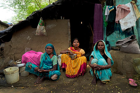 Three women of the Manjhi community Sonpatiya, Reshmi Devi, and Phulmanti Devi sit outside their modest home, reflecting the daily struggle for basic amenities.