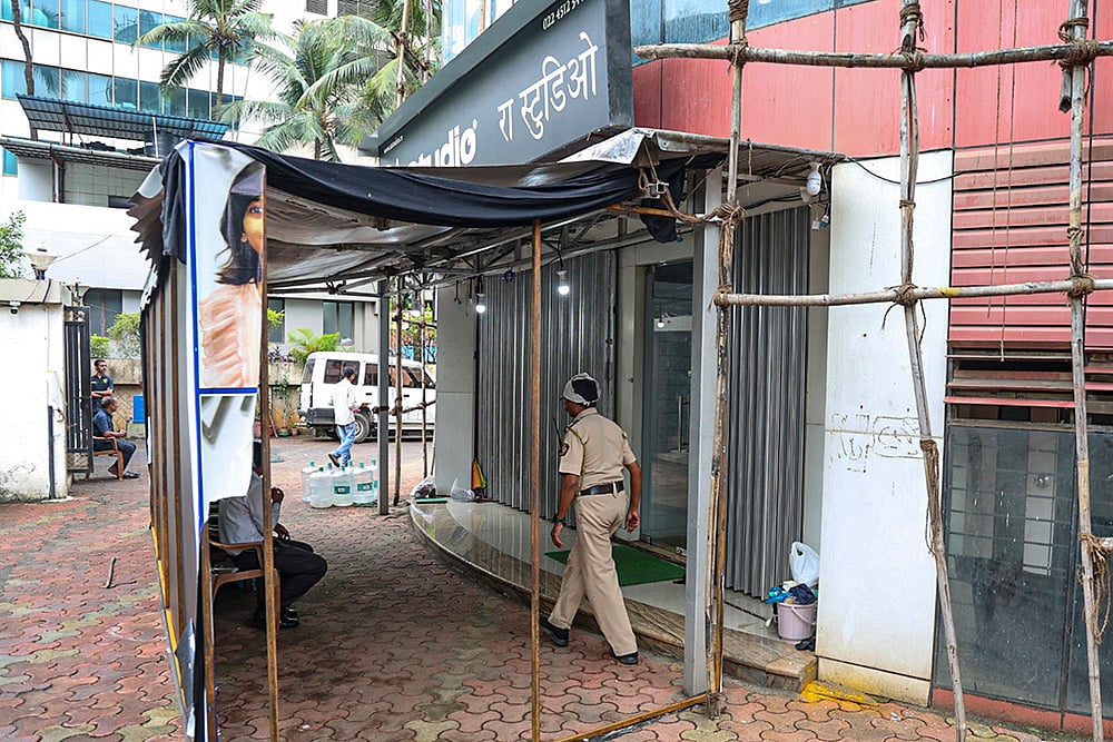 | Photo: PTI : A police official keeps a vigil outside R A Studio, where a man held 19 persons including 17 teenage children hostage yesterday, at Powai area, in Mumbai, Maharashtra.