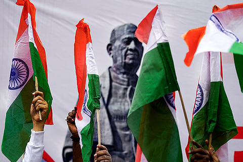 People raise the Tricolour during the Run for Unity organised to mark the 150th birth anniversary of Sardar Vallabhbhai Patel as part of the National Unity Day celebrations, in Varanasi.