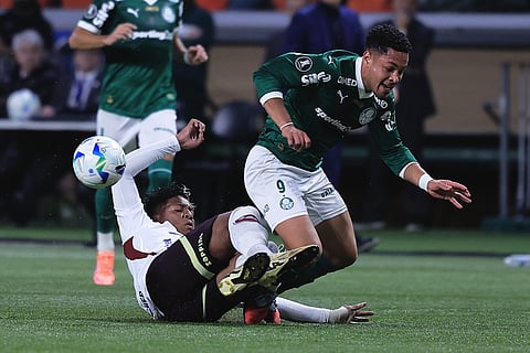 Vitor Roque of Brazil's Palmeiras, right, is tackled by Richard Mina of Ecuador's Liga Deportiva Universitaria during a Copa Libertadores semifinal second leg soccer match in Sao Paulo.