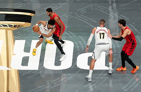 Denver Nuggets guard Jamal Murray, left, tries to get around Portland Trail Blazers forward Kris Murray, second from left, during the second half of an NBA Cup basketball game in Portland, Ore.