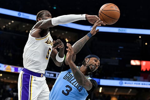 Memphis Grizzlies guard Kentavious Caldwell-Pope (3) and Los Angeles Lakers center Deandre Ayton (5) contend for control of the ball in the first half of an NBA Cup basketball game in Memphis, Tenn.