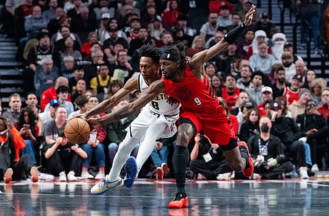 Portland Trail Blazers forward Jerami Grant (9) attempts to steal the ball from Denver Nuggets guard Peyton Watson (8) during the first half of an NBA Cup basketball game in Portland, Ore.