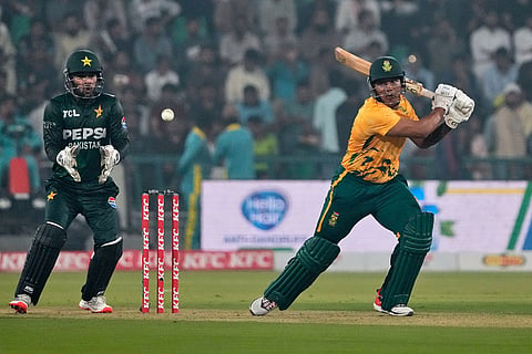 South Africa's Ottneil Baartman, right, plays a shot as Pakistan's Usman Khan watches during the second T20 cricket match between Pakistan and South Africa, in Lahore, Pakistan.