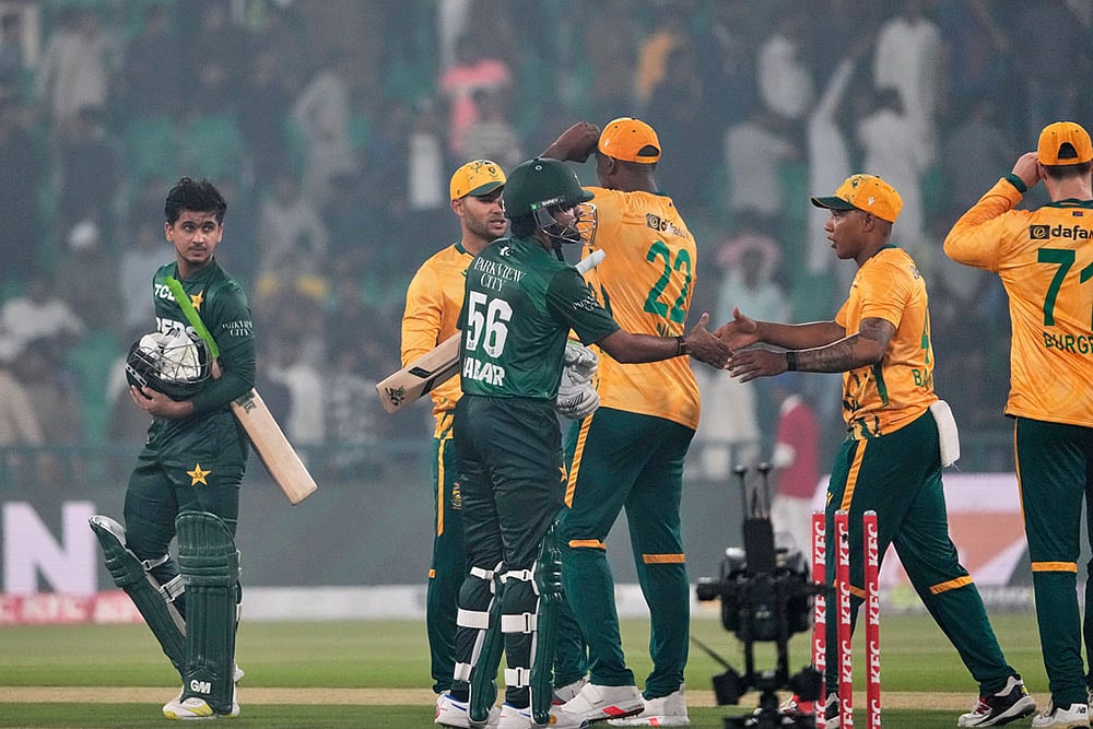 | Photo: AP/K.M. Chaudary : Pakistan's Saim Ayub, left, and Babar Azam, second left, shake hand with South African players on the end of the second T20 cricket match between Pakistan and South Africa, in Lahore, Pakistan.