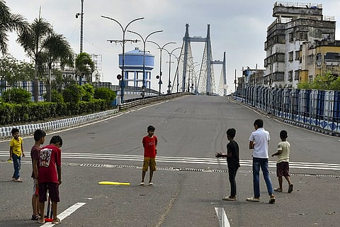 Children play on a nearly deserted road leading to the Vidyasagar Setu, also known as the second Hooghly bridge, on which vehicular movement has been restricted citing repair and rehabilitation, in Kolkata.