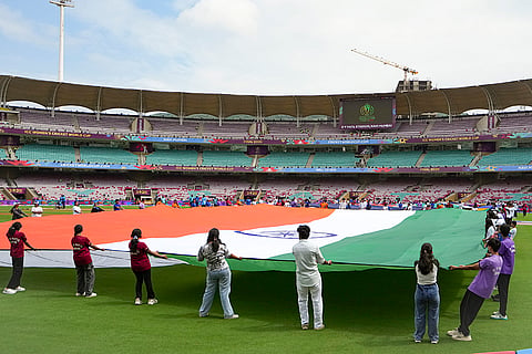 People hold the national flag as part of rehearsals at DY Patil Stadium ahead of the ICC Women's World Cup 2025 cricket final match between India Women and South Africa Women, in Navi Mumbai.