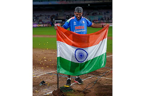 India’s coach Amol Muzumdar plants the Indian tricolour on the pitch after the team won the ICC Women's World Cup 2025, at the DY Patil Stadium, in Navi Mumbai.