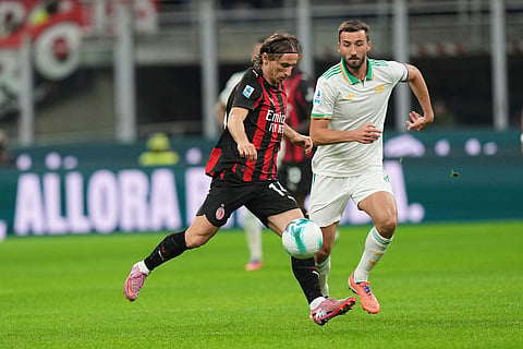 AC Milan's Luka Modric, centre, and Roma's Bryan Cristante challenge for the ball during the Serie A soccer match between AC Milan and Roma in Milan, Italy.