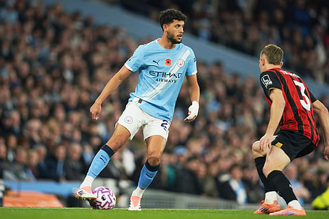Manchester City's Matheus Nunes, centre, challenges for the ball with Bournemouth's Adrien Truffert during the English Premier League soccer match between Manchester City and Bournemouth in Manchester, England.