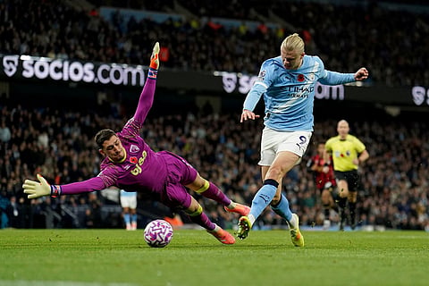 Manchester City's Erling Haaland scores his side's second goal past Bournemouth's goalkeeper Dorde Petrovic during the English Premier League soccer match between Manchester City and Bournemouth in Manchester, England.