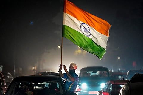 A man waves the Indian tricolour in celebration after the Indian cricket team won the ICC Women's World Cup 2025, near the India Gate, in New Delhi.