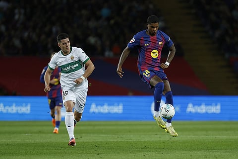Barcelona's Marcus Rashford, right, runs with the ball past Elche's Martim Neto during a Spanish La Liga soccer match between FC Barcelona and Elche CF in Barcelona, Spain.