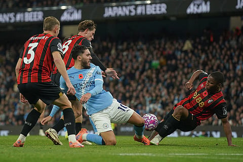 Manchester City's Rayan Cherki, centre, challenges for the ball with Bournemouth's Bafode Diakite, right, during the English Premier League soccer match between Manchester City and Bournemouth in Manchester, England.
