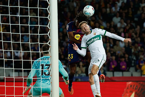 Barcelona's Jules Kounde, center, heads the ball past Elche's Marc Aguado during a Spanish La Liga soccer match between FC Barcelona and Elche CF in Barcelona, Spain, Sunday, Nov. 2, 2025. ()