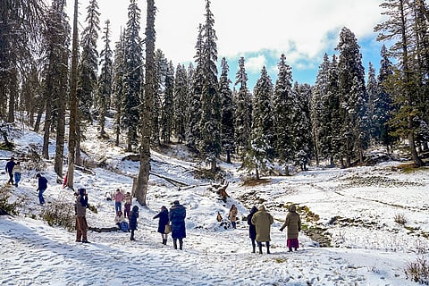 Tourists seem to enjoy as a thick white layer blankets the Gulmarg area after the season's first snowfall, in Baramulla.
